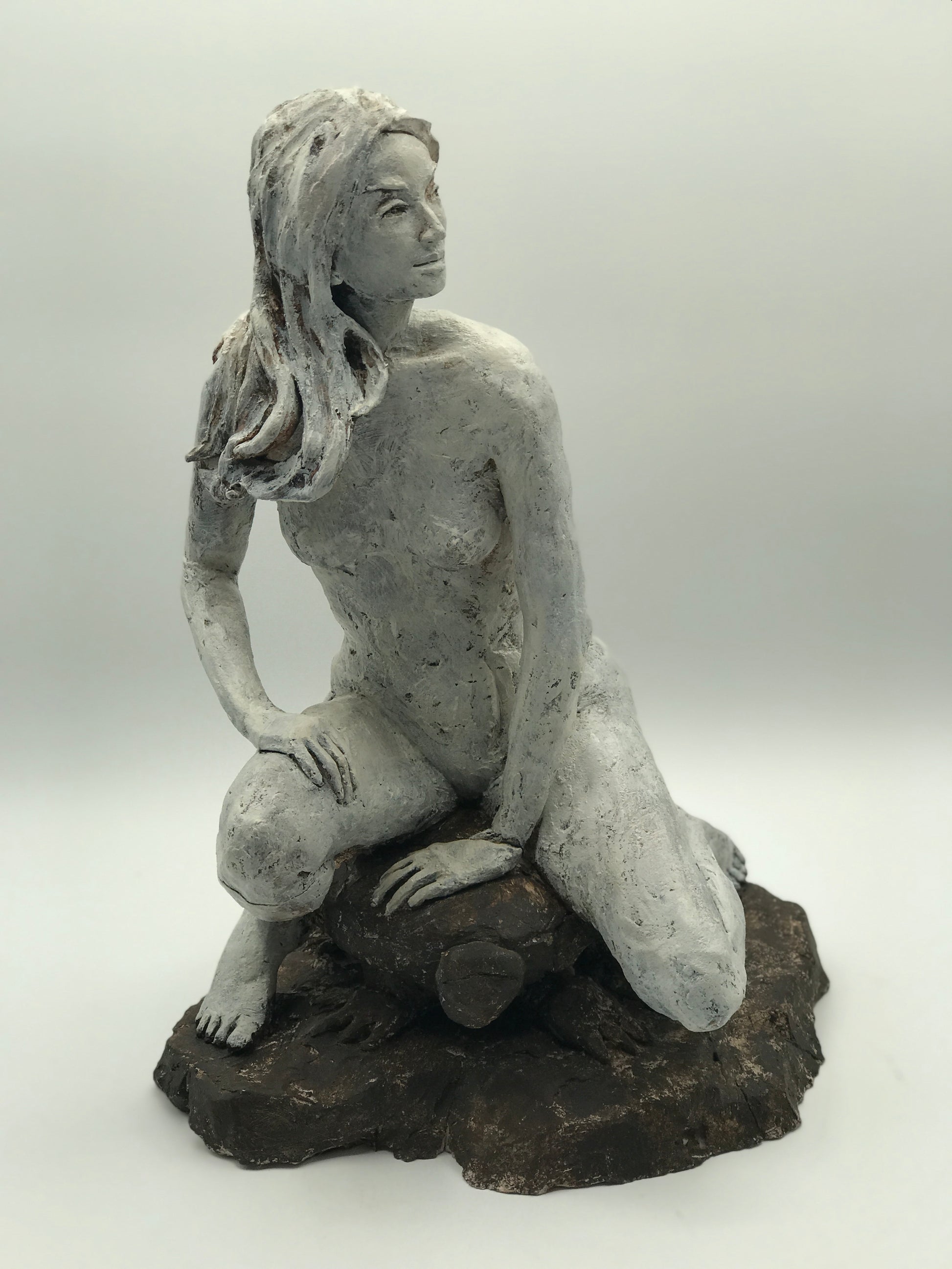 Clay figure sculpture of a woman seated on a turtle