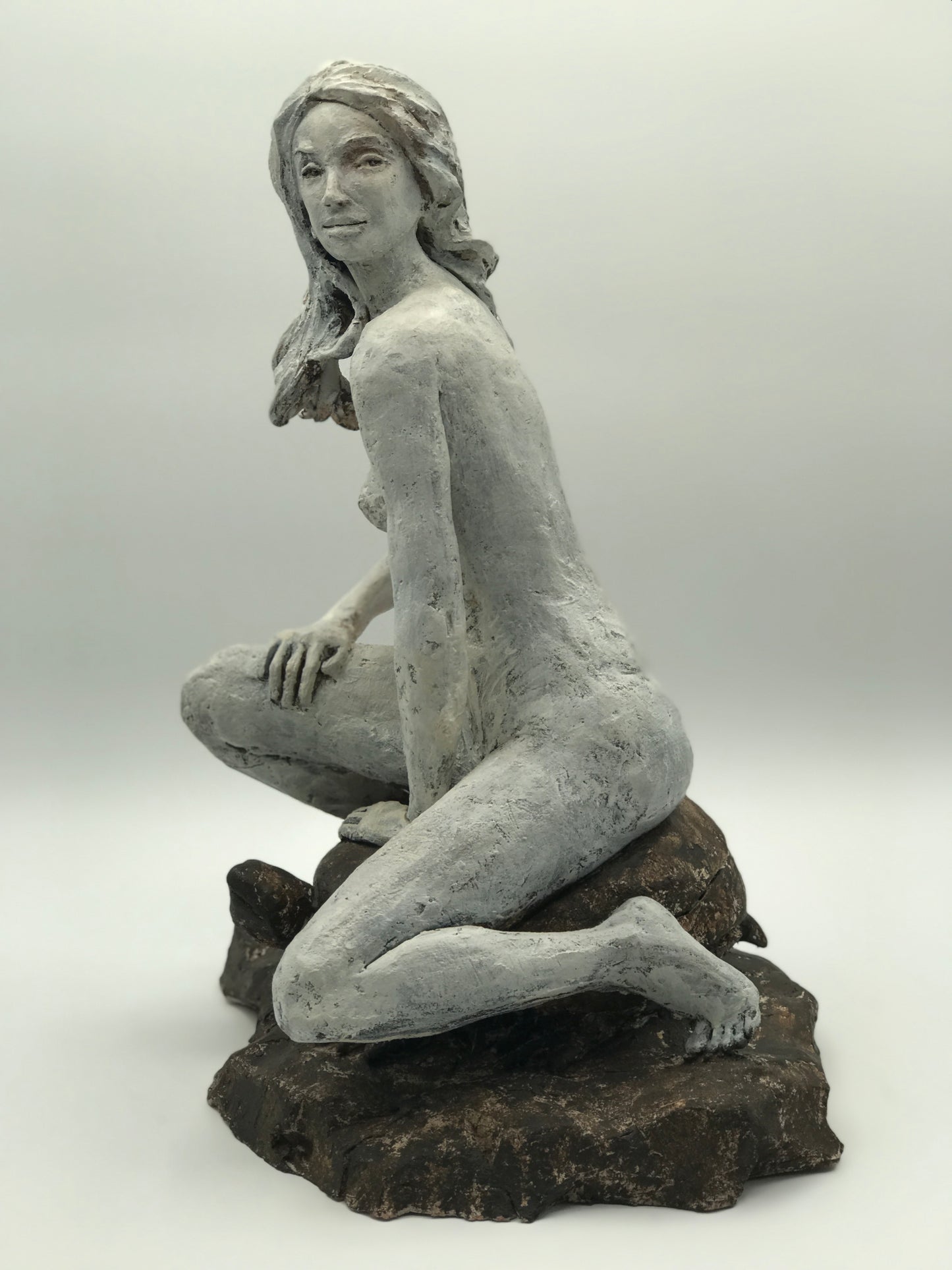 Clay figure sculpture of a woman seated on a turtle